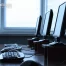 Three desktop computers with monitors, keyboards, and mice are arranged in a row on a desk in front of windows with blinds. The "TechWaste Recycling" logo is visible in the corner.