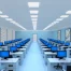 Rows of desks with computers in a brightly lit office. Several charts with upward trends are displayed on the walls. The room appears empty of people.