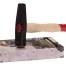 A hammer rests on top of a computer hard drive, suggesting potential damage or destruction of the device.